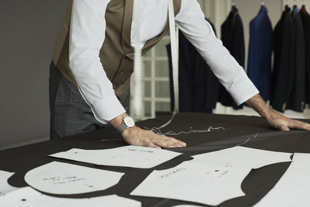 Alessandro Albanese at his cutting table, draping and marking patterns