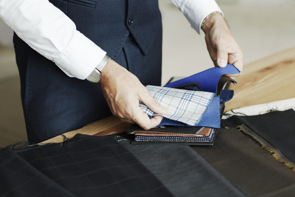 Alessandro Albanese reviewing fabric swatches for a custom riding coat