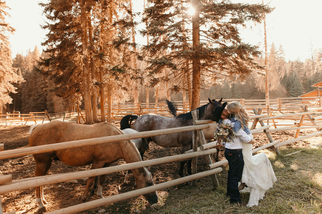 Sarah and Zak Big Sky Montana wedding, bridal kiss in front of horses
