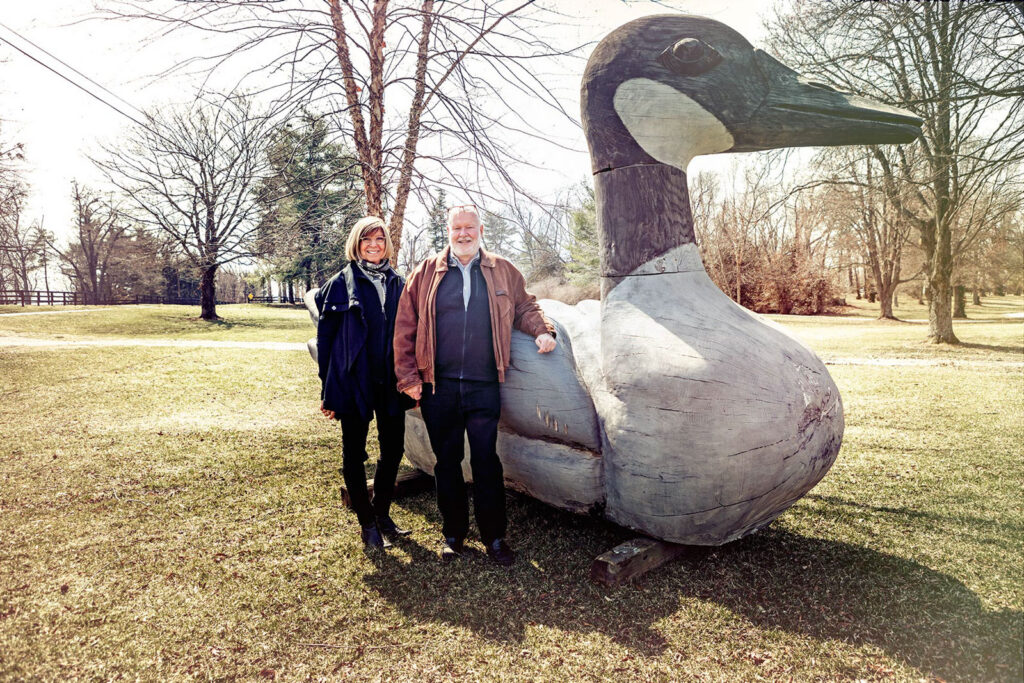 Stephanie Peters and C. W. Medinger standing beside a giant goose sculpture on the Kentucky cross-country course