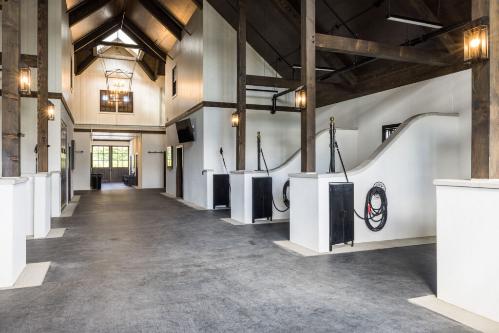 Grooming and wash bays with white curved walls, dark timber posts and lantern sconces