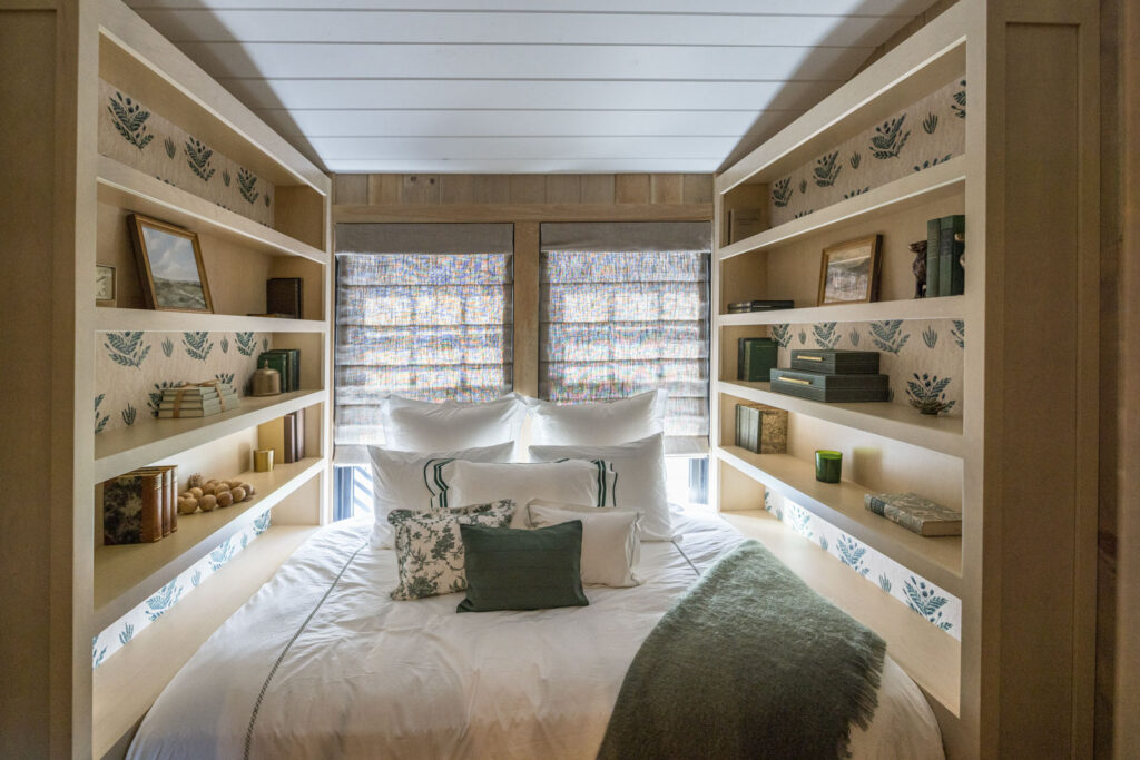 Guest bedroom framed by built-in shelving on both sides of the bed