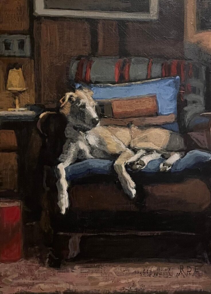 Dennis, an oil painting by Romy Elliott of a pale lurcher stretched out on a sofa with patterned cushions