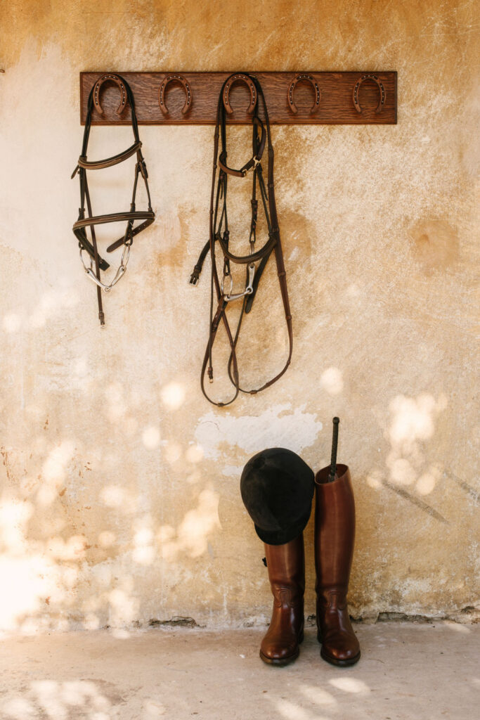 Versatile Horseshoe Bridle Rack with helmet and boots in the American Stalls tack room