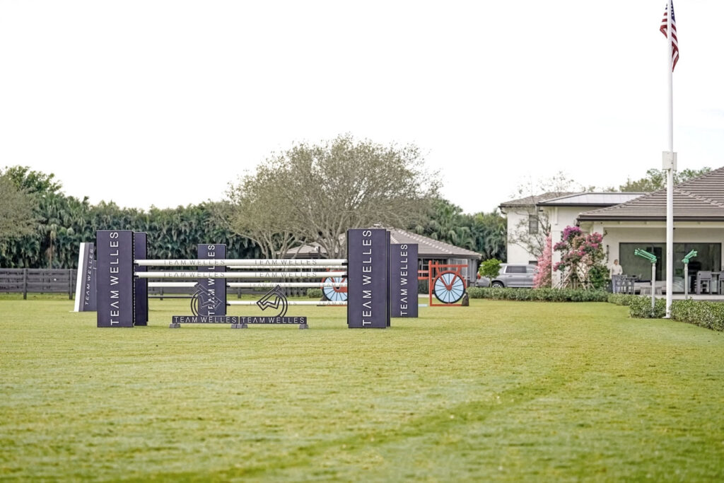 Team Welles branded jump standards on the schooling field at their Wellington, Florida farm