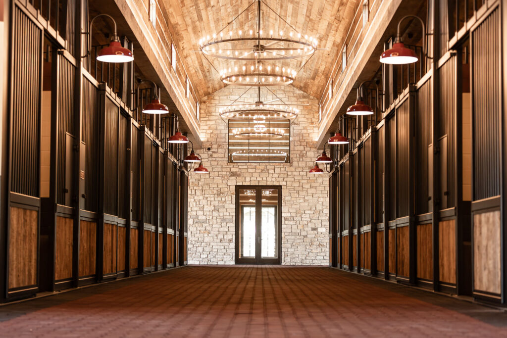 Chandelier-lit barn aisle inside the 6666 Stallion Station