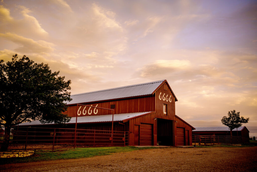 The red 6666 L Barn at the Four Sixes Ranch at sunset